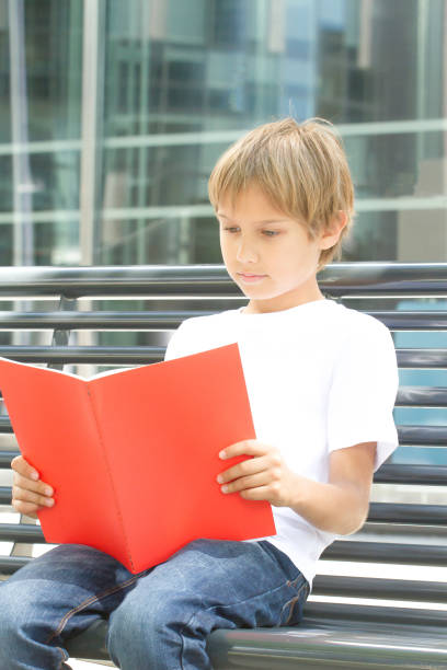 istock Schoolboy reading books. Kid doing homework outdoors. Back to school concept. 827860302