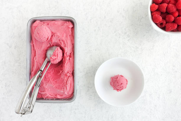 istock Scoops of Raspberry Ice Cream in Tub and Raspberries 827863150