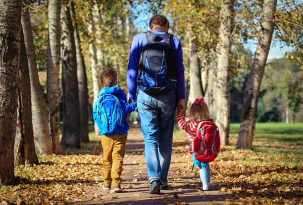 istock father with little son and daughter going to school 827867152