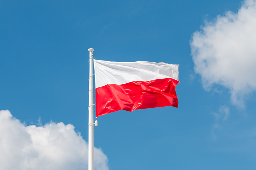 Waving national flag of Poland on a flagpole, national colors of Poland.