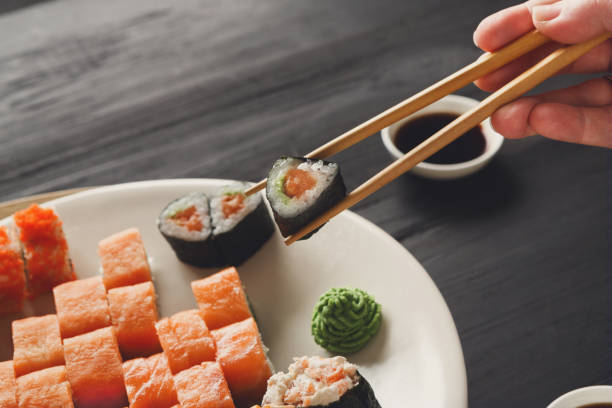 istock Eating sushi and rolls in japanese restaurant 827871188