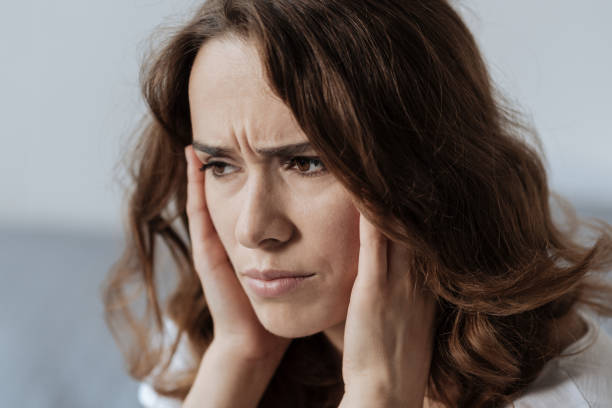 istock Beautiful young woman holding her head 827871448