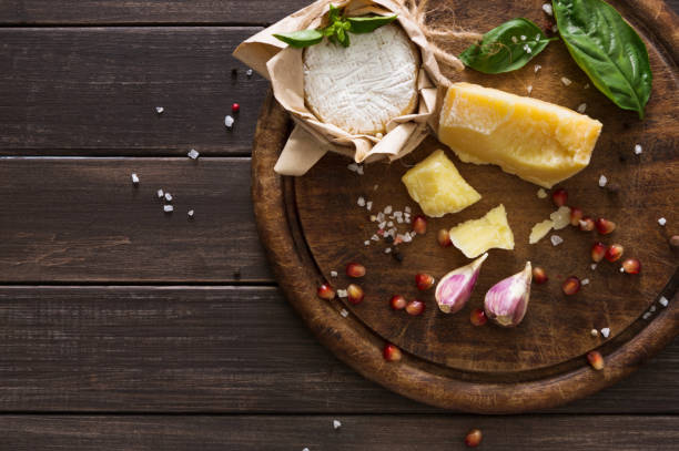 istock Cheese delikatessen closeup on rustic wood, brie and parmesan 827871708