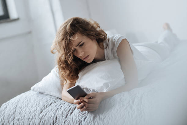 istock Cheerless young woman looking at her smartphone 827874704