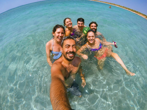 istock Group of multiracial happy friends taking fun selfie 827878644