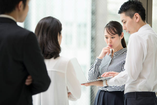 istock have a serious conversation with a man holding a computer with one hand 827879510