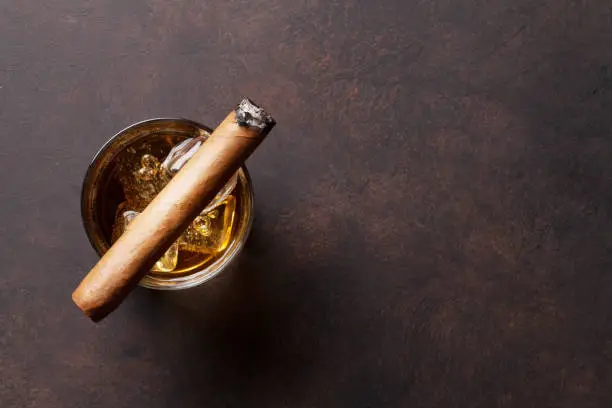 Whiskey with ice and cigar. Top view with copy space