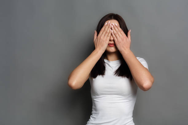 istock Scared woman covering eyes with hands, see no evil 827879710
