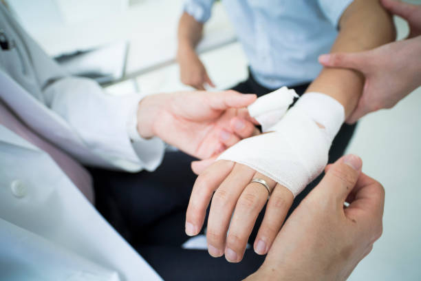 un hombre que llevaba un anillo de bodas tiene un médico para recibir una prestación por lesiones. - bandage fotografías e imágenes de stock