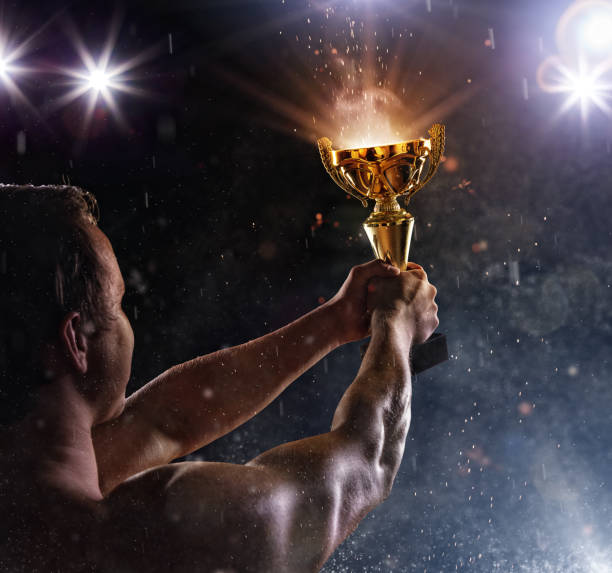 istock Back view of man fighter with trophy cup in hands, victory gesture 827881290