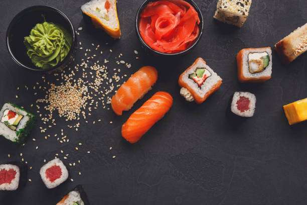 istock Sushi and rolls background, closeup on black, top view. 827881832