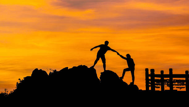 istock silhouette of couple help each other trust assistance in sunset 827887788