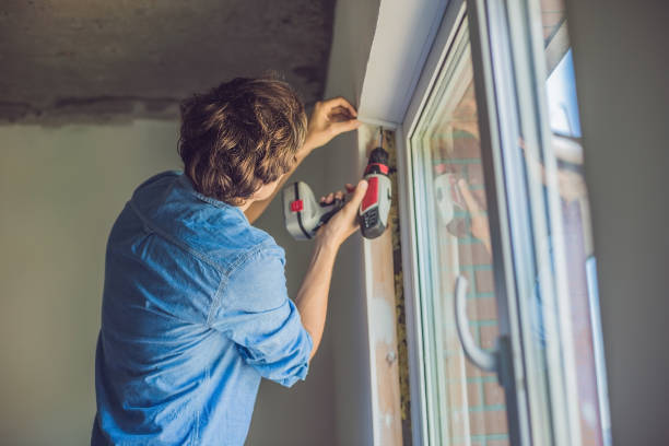 istock Man in a blue shirt does window installation 827891400