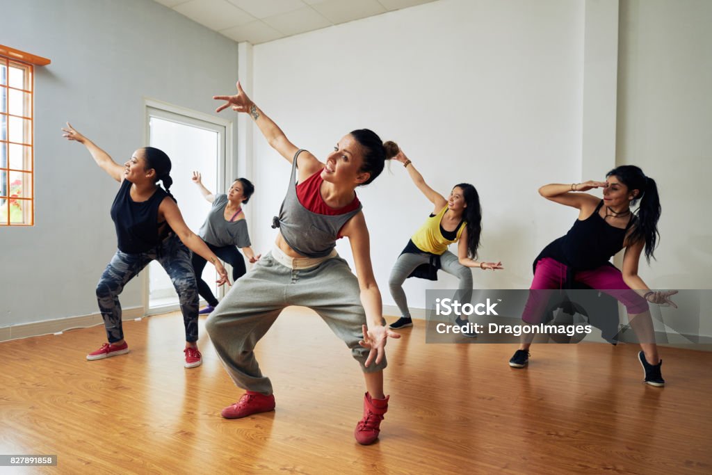 Hip-Hop Dancers Having Training Group of energetic hip-hop dancers focused on training while gathered together in spacious dance hall Dancing Stock Photo