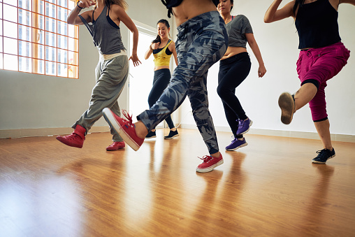 Sporty women enjoying each others company while doing leg swings during fitness training