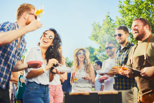 istock Group of people standing at barbecue party 827892542