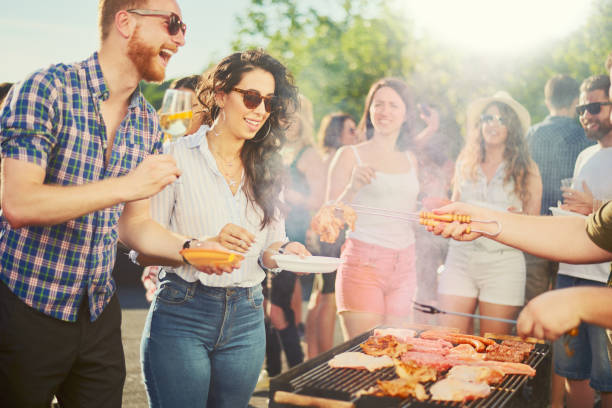 istock Group of people standing at barbecue party 827892584