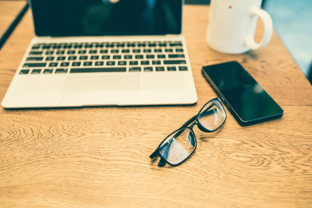 istock Eyeglasses,laptop,phone on table 827895550