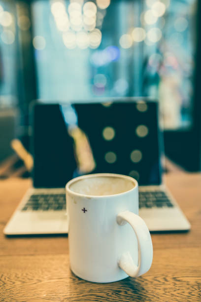 istock cup of coffee with laptop on a wooden table 827895884