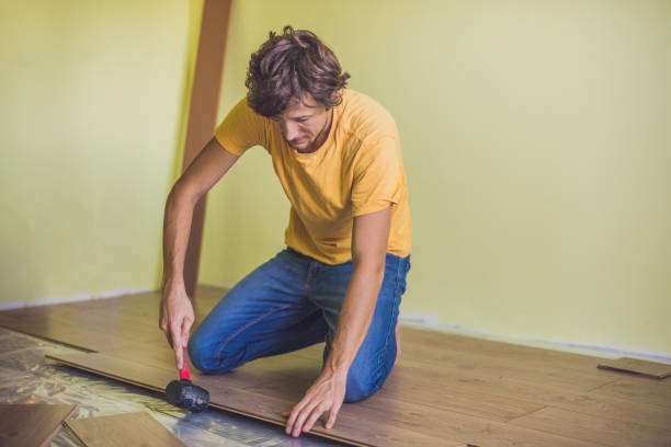 istock Man installing new wooden laminate flooring. infrared floor heating system under laminate floor 827901266