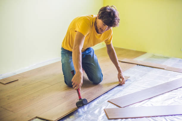 istock Man installing new wooden laminate flooring. infrared floor heating system under laminate floor 827901276