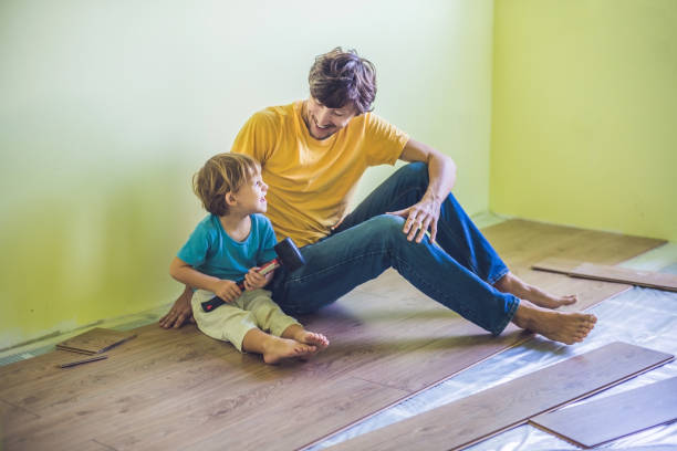 istock Father and son installing new wooden laminate flooring. infrared floor heating system under laminate floor 827901474