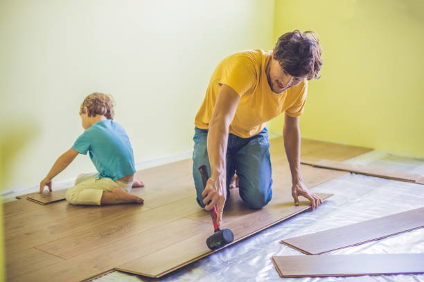 istock Father and son installing new wooden laminate flooring. infrared floor heating system under laminate floor 827901490