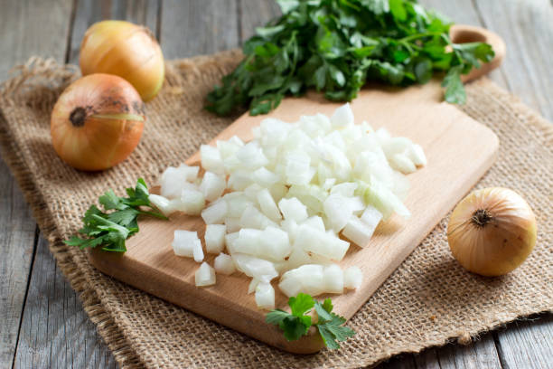 istock Chopped onions on wooden cutting board 827901936