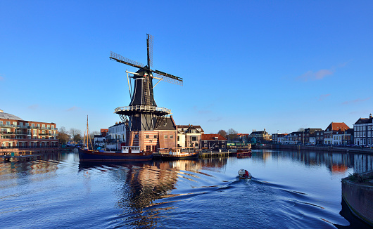 Traditional windmill at prinsengracht canal in blue sky at sunset, Amsterdam, Netherlands.