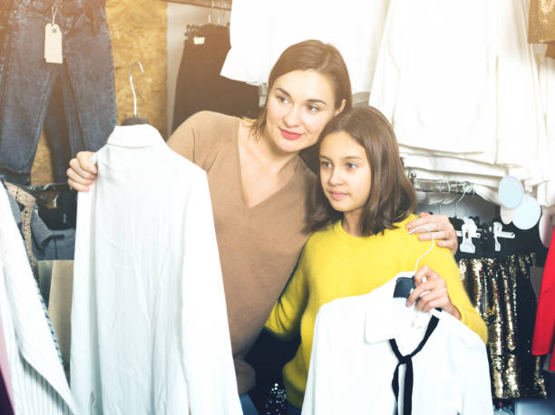 istock Mother and daughter examining various blouses 827904836