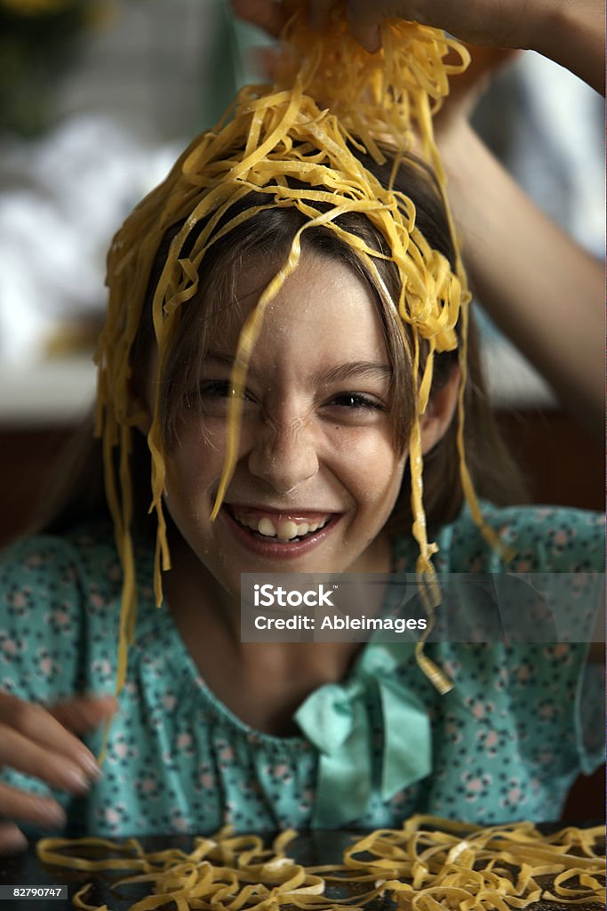 girl putting pasta on head  Child Stock Photo