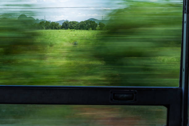 Motion blur train window view with green trees and sky stock photo