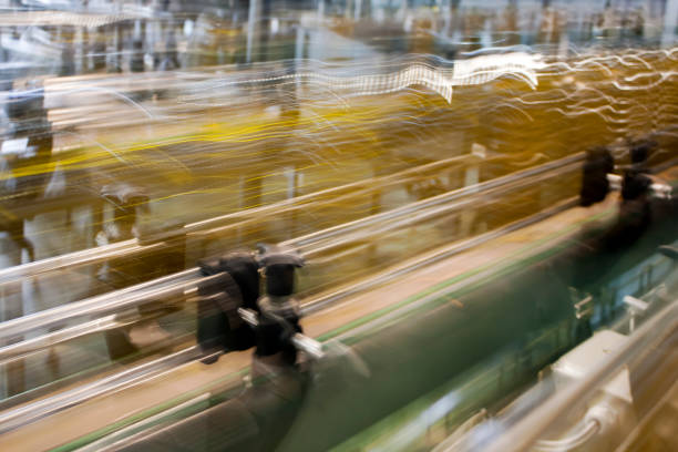 Packaging machinery, bottling cooking oil, row of bottles on conveyor belt, long exposure, quick movement effect. Copy space available on the right.