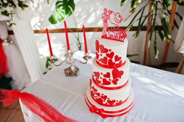 istock Amazing red and white wedding cake standing on the table. 827921454
