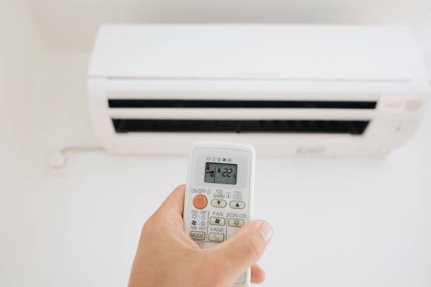 istock Hand adjusting temperature of home air conditioner 827926024