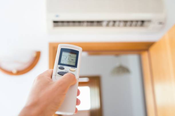 istock Hand adjusting temperature of home air conditioner 827928288