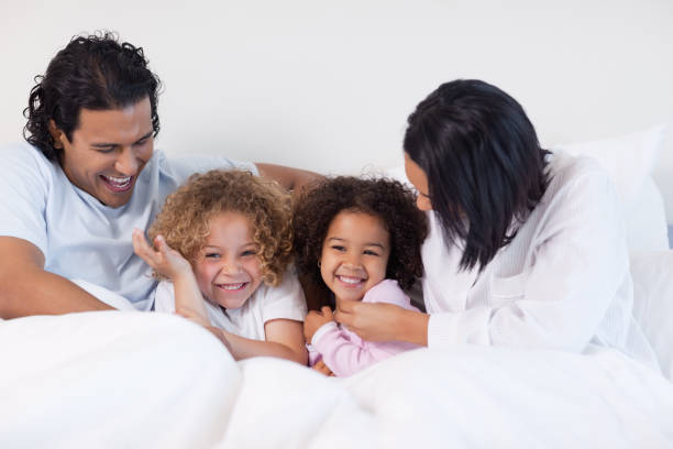 istock Smiling family sitting on the bed 827928336