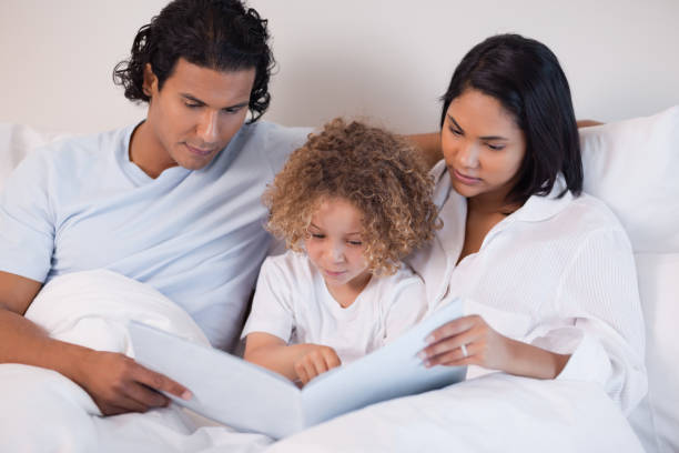 istock Happy family enjoys reading a book together 827928580