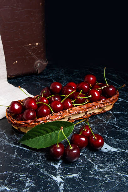 Several red sweet cherries and big green leaf