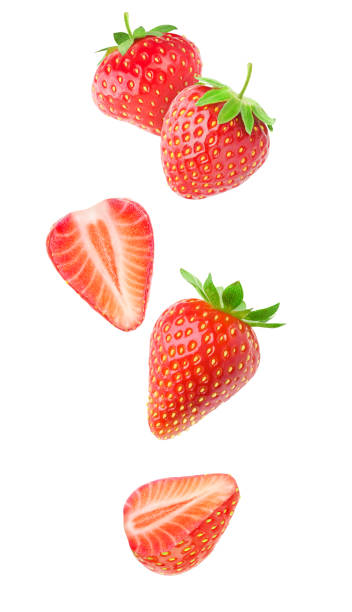 Isolated falling strawberries Isolated strawberries. Falling strawberry fruits whole and cut in half isolated on white background with clipping path halved stock pictures, royalty-free photos & images