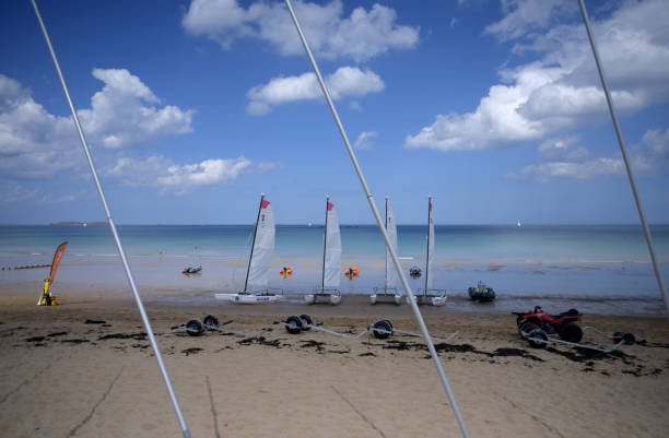 29 April 2017. Le Sillon beach, St. Malo, Brittany, France. Windsurfers and rubber dinghys lined up on the beach waiting for the days activities to begin.