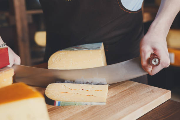 istock Cutting hard cheese in grocery shop 827950484