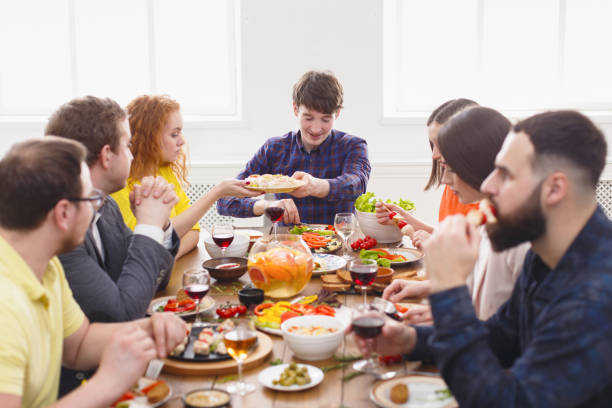 istock Group of happy people at festive table dinner party 827952792