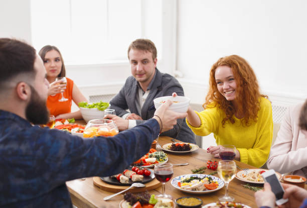 istock Group of happy people at festive table dinner party 827954264