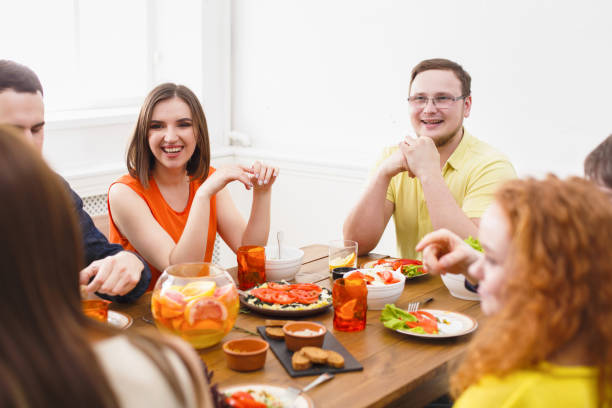 istock Group of happy people at festive table dinner party 827954696