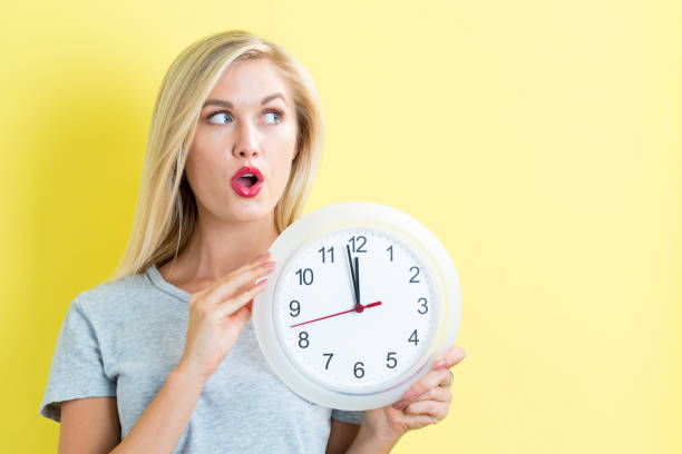 istock Woman holding clock showing nearly 12 827960994