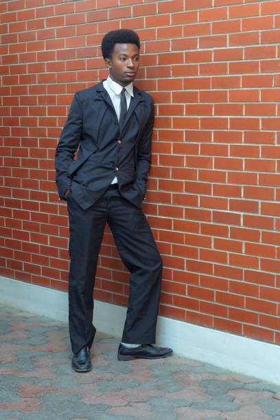 istock young businessman wearing suit and tie full length brick wall 827962400