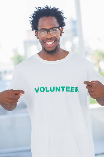 istock Cheerful man pointing to his volunteer tshirt 827962916