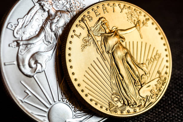 silver eagle and golden american eagle one ounce coins closeup of silver eagle and golden american eagle one ounce coins on black background ingot photos stock pictures, royalty-free photos & images