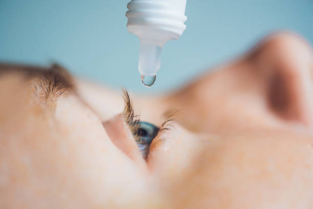 Closeup of eyedropper putting liquid into open eye stock photo